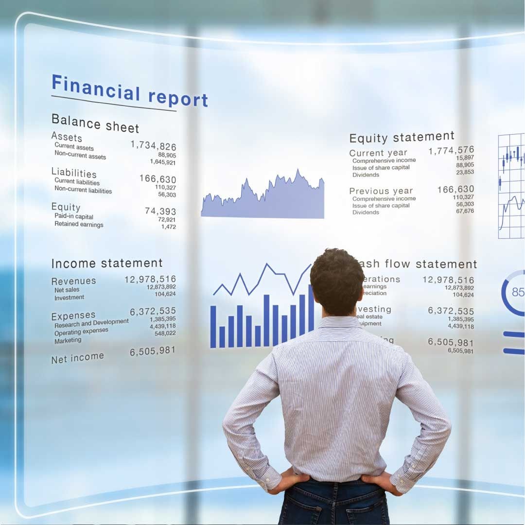 A man stands in front of a large semi-transparent display showcasing various types of financial data.