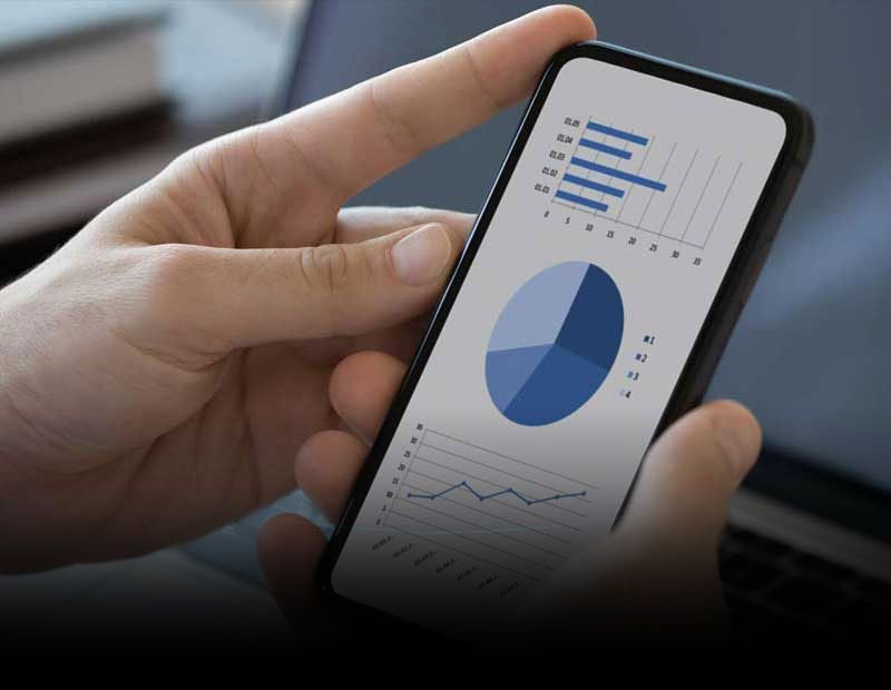 A person’s hands holding a mobile phone displaying financial data.